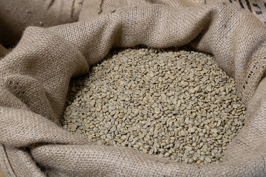 Een zak vol met groene koffiebonen klaar om gebrand te gaan worden voor overheerlijke kop verse koffie.