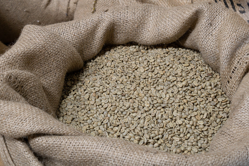 Een zak vol met groene koffiebonen klaar om gebrand te gaan worden voor overheerlijke kop verse koffie.